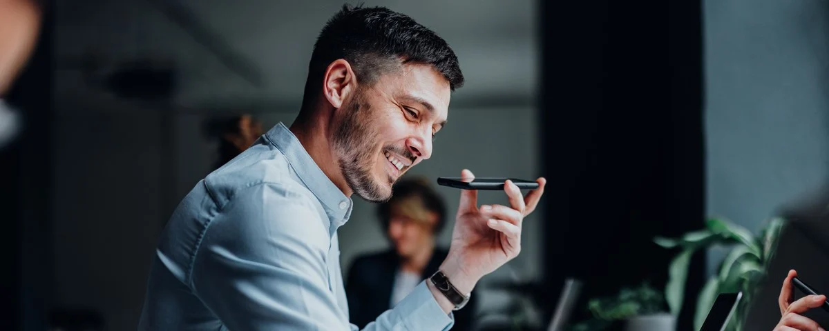 Professionnel souriant qui utilise son téléphone d'entreprise