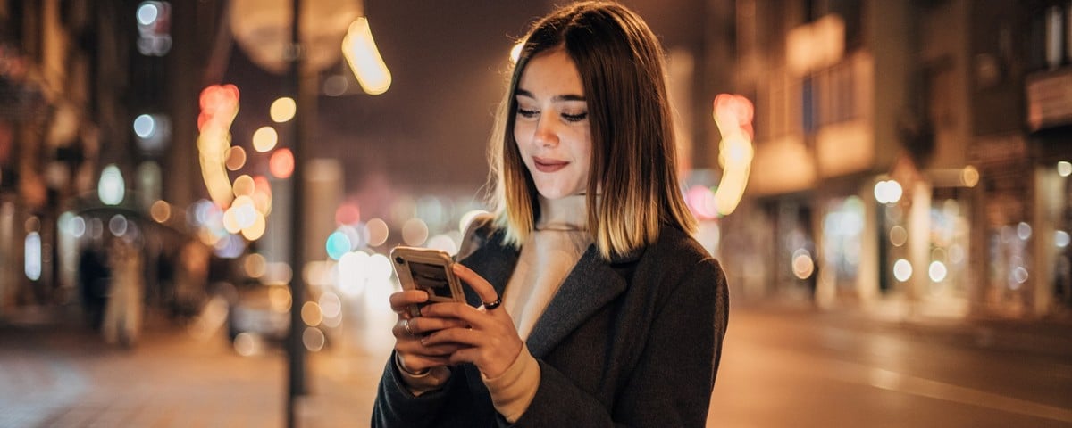 une femme aziatique tennant son smartphone